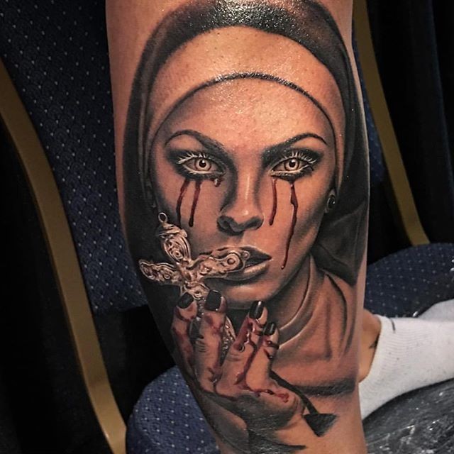 小腿流血的女性肖像和十字架纹身图案