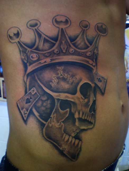 侧肋骷髅戴皇冠和扑克牌纹身图案