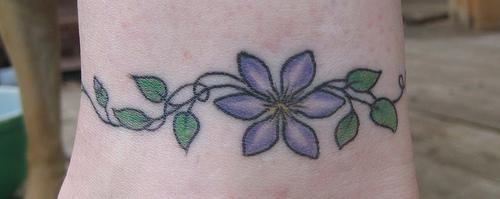 女性腿部彩色紫罗兰花朵纹身图案
