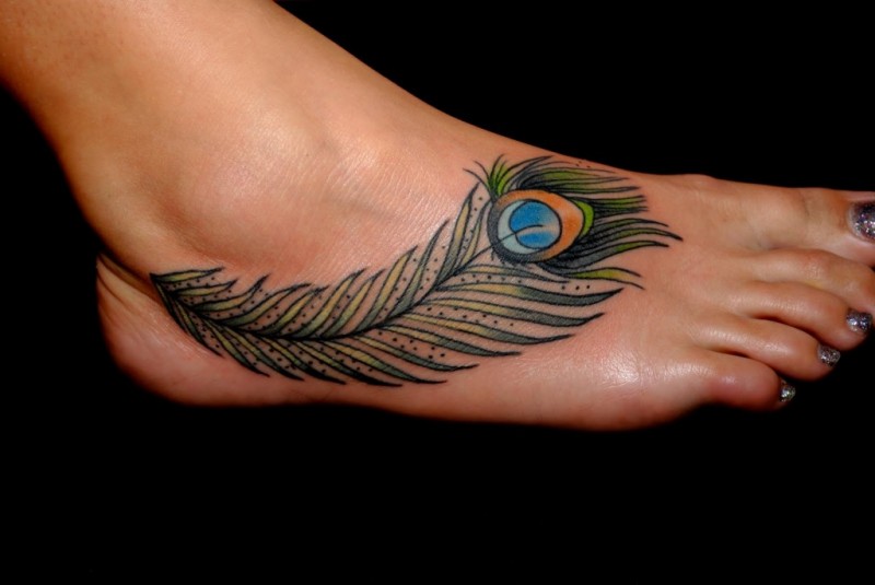 女性脚背上绿色的孔雀羽毛纹身图案