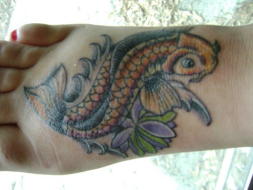 脚背上的彩色鱼与花朵纹身图案