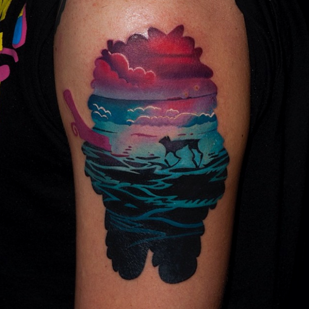 大臂彩色狗剪影与海边风景纹身图案