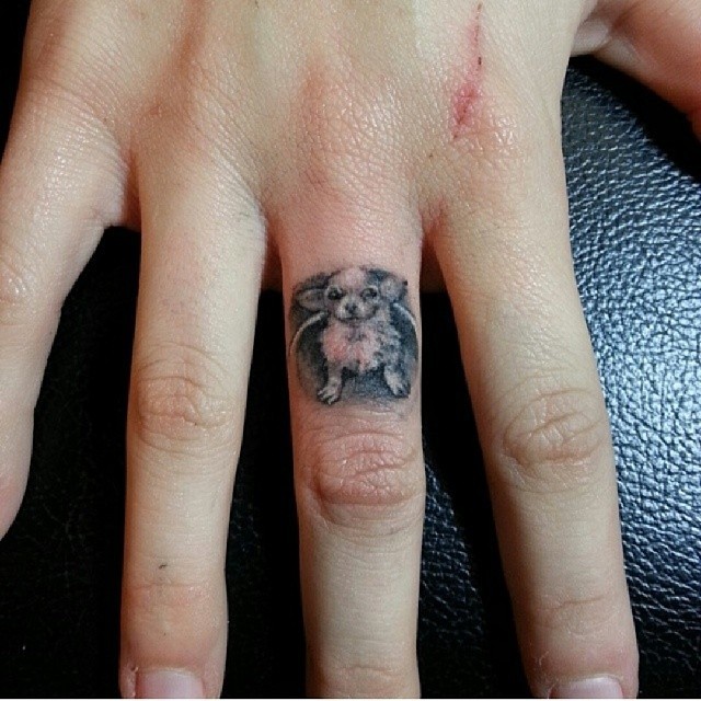 手指可爱的小黑白狗纹身图案