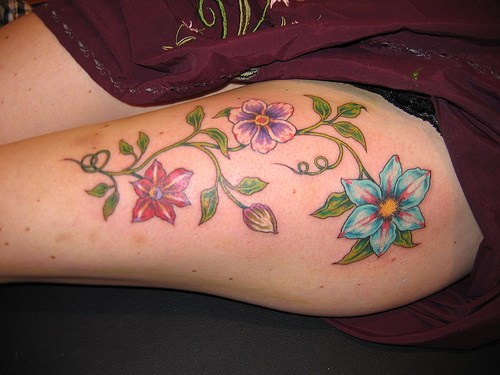 腿部彩色植物上的五颜六色花朵纹身