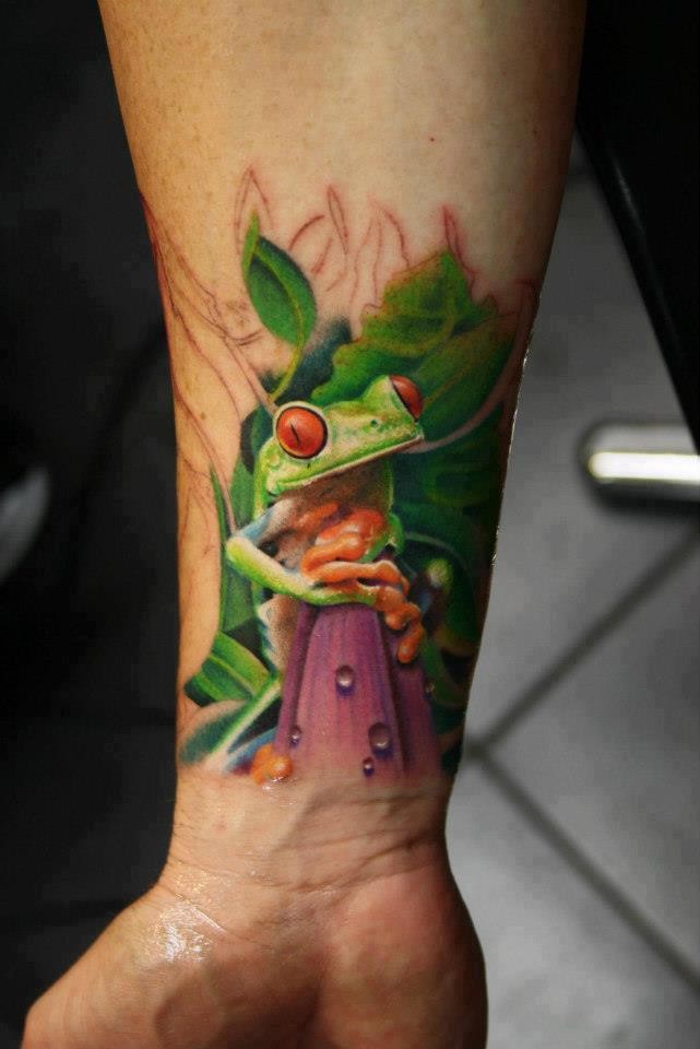 手腕上逼真的绿色小青蛙纹身图案