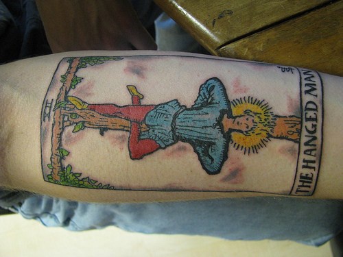 手臂彩色挂在树上的人纹身图案