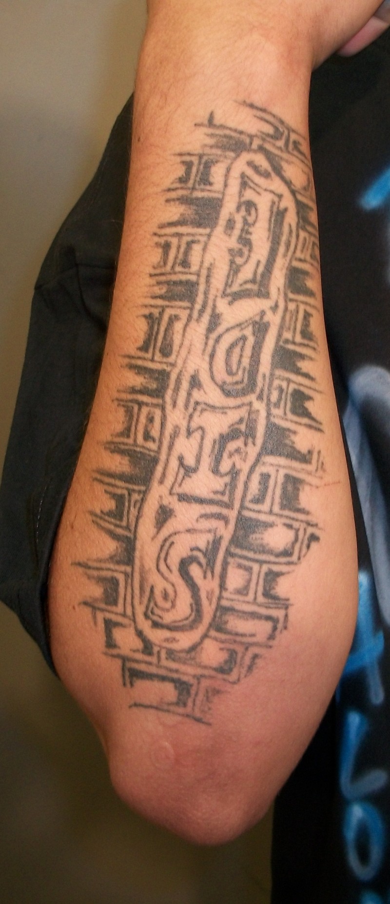手臂黑色砖墙上的英文字母纹身图案