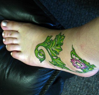 女性脚背绿色植物与花朵纹身图案