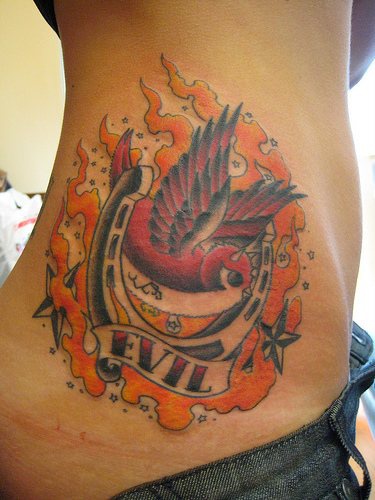 腰部邪恶麻雀和马蹄铁火焰纹身图案