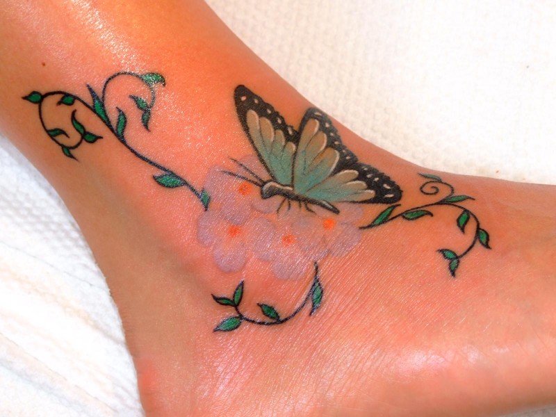 女孩脚部彩色花朵与蝴蝶纹身图案