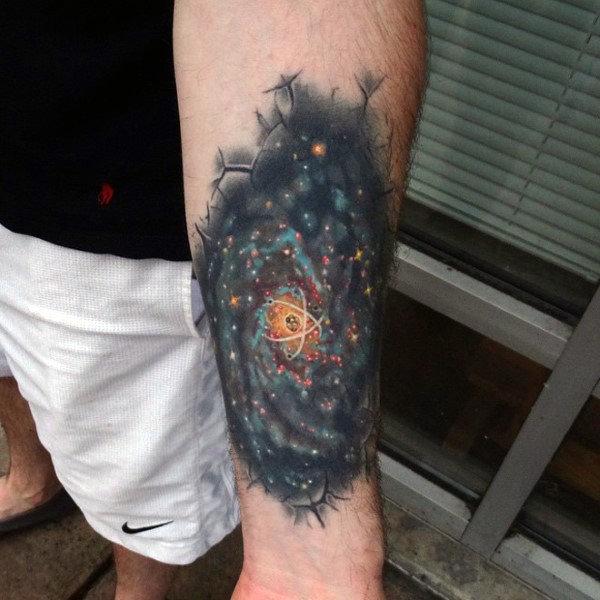 手臂壮观的彩色星空空间与原子纹身图案