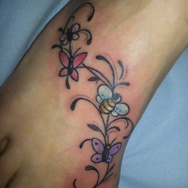 女性脚背彩色蝴蝶蜜蜂和鲜花纹身图片