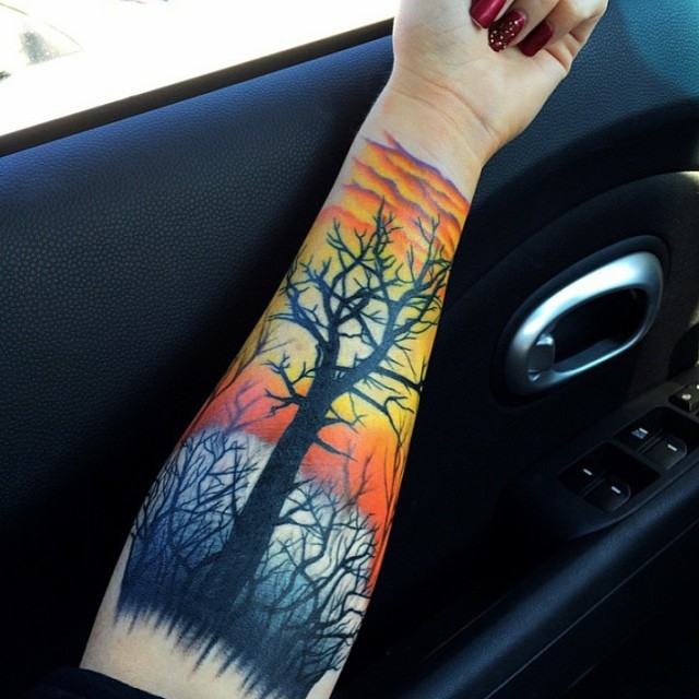 手臂彩色漂亮的黑树和日落纹身图案