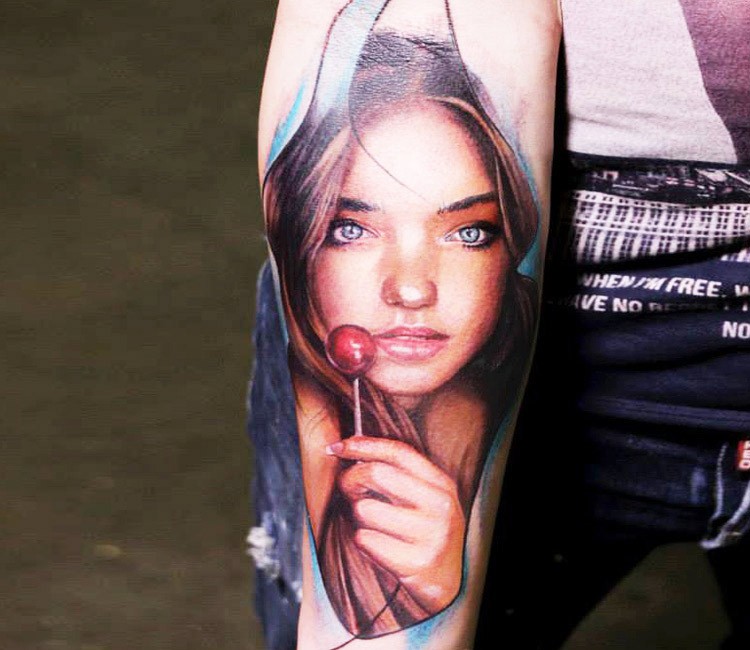 手臂彩色逼真的女孩肖像与棒棒糖纹身