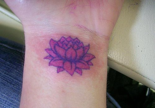 女性手腕上的紫色莲花纹身图案