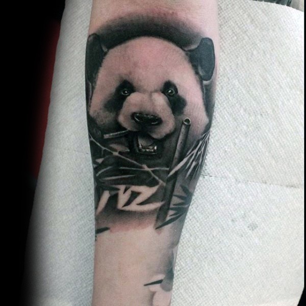 手臂黑白色逼真的熊猫吃竹子纹身图片