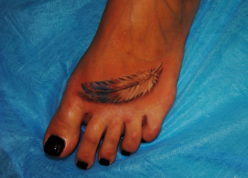 女性脚背逼真的羽毛纹身图案