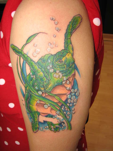 肩部绿海龟在海洋中游泳的纹身