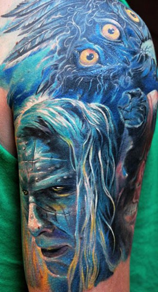 大臂蓝色风格神秘男人脸和羽毛纹身图案