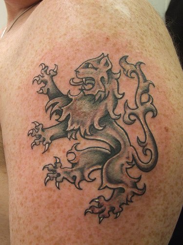 男性肩部咆哮的狮子纹身图案