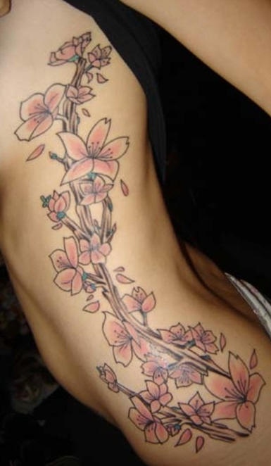 女性腰侧彩色桃花藤蔓纹身图案