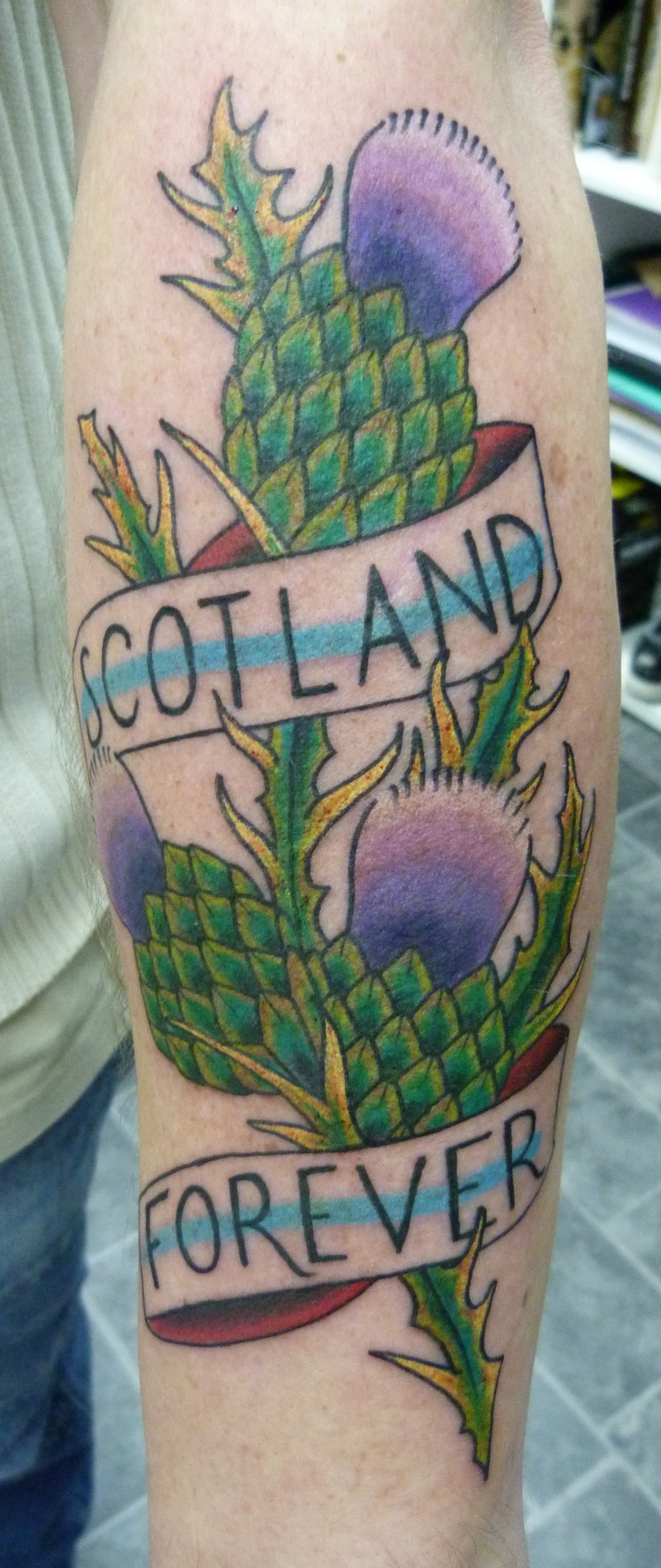 手臂彩色苏格兰字母与植物纹身