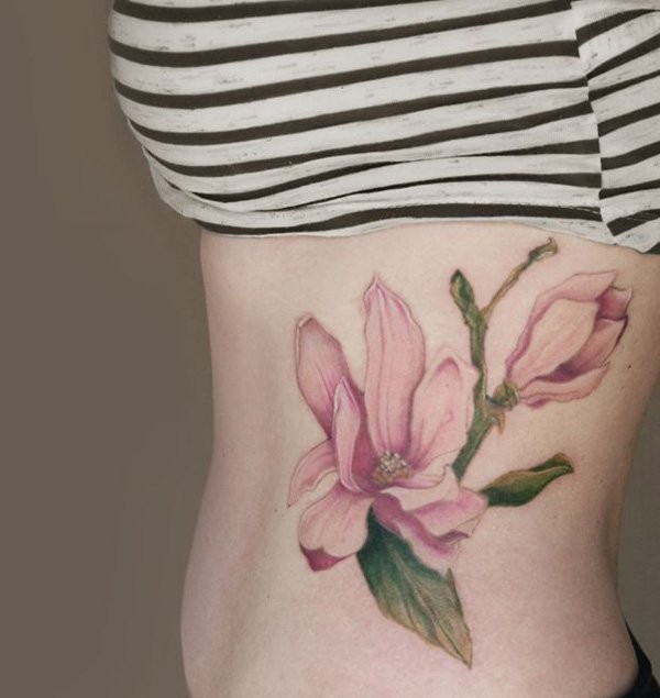 女性腰侧粉红色花朵纹身图案
