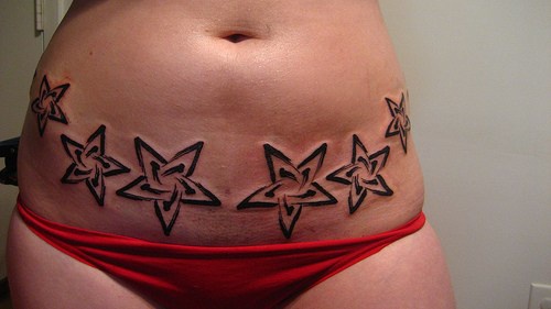 女性腰部黑色五角星纹身图案
