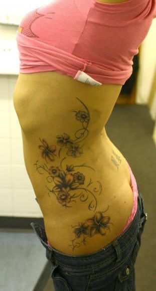 女性腰侧彩色花藤纹身图案