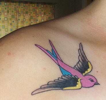 女性肩部飞行的彩色燕子纹身图案