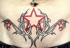 腹部灌木丛中红色的星星纹身图案