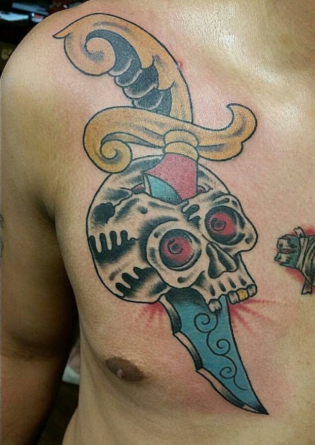男子胸部上的大头骨和匕首纹身图片