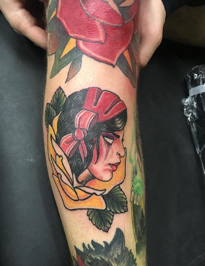 花臂膀上的红色和黄色玫瑰花里的女子肖像纹身