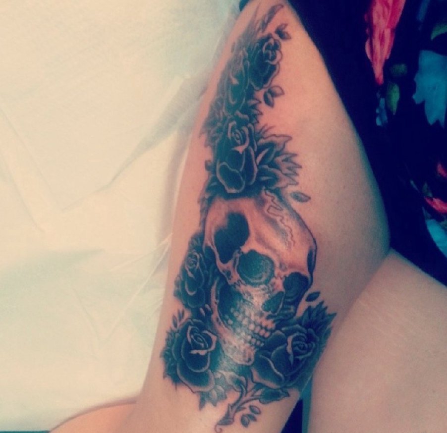 女性性感大腿上的黑色玫瑰花朵和骷髅头纹身