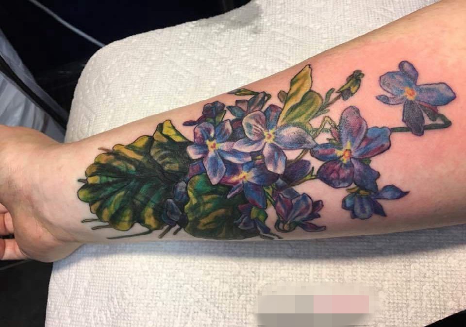 男生手臂上彩色渐变植物花朵纹身图片