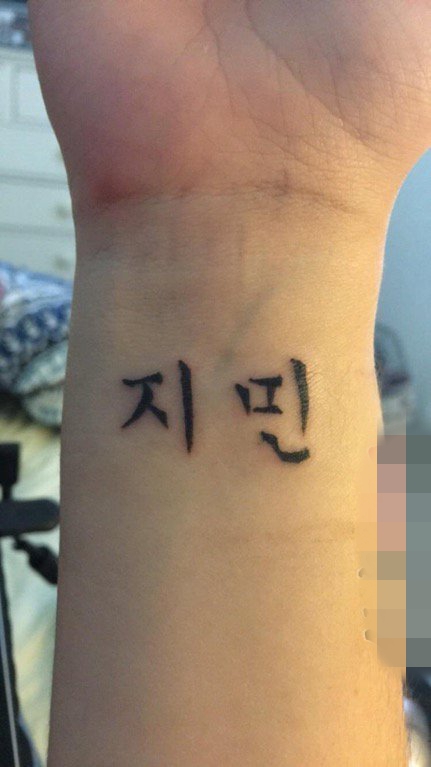 女生手臂上黑色简单韩文纹身图片