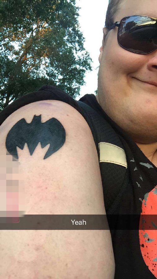 女生手臂上黑色轮廓蝙蝠侠图标纹身图片