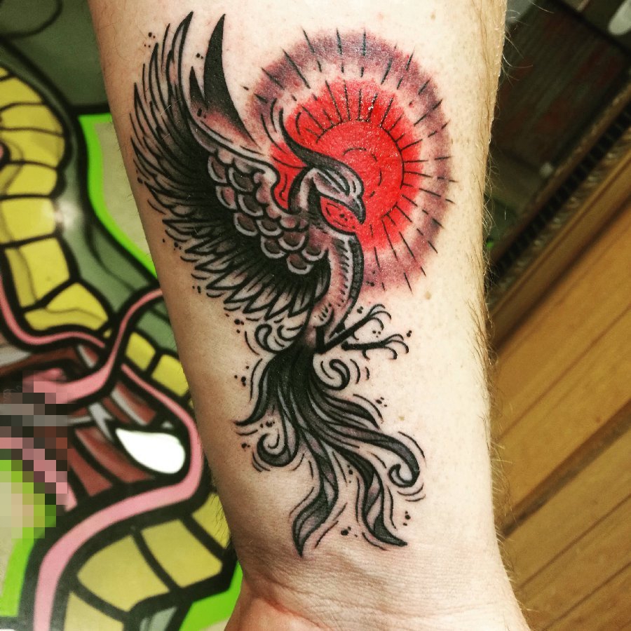 男生手臂上黑色素描凤凰和红色太阳纹身图案