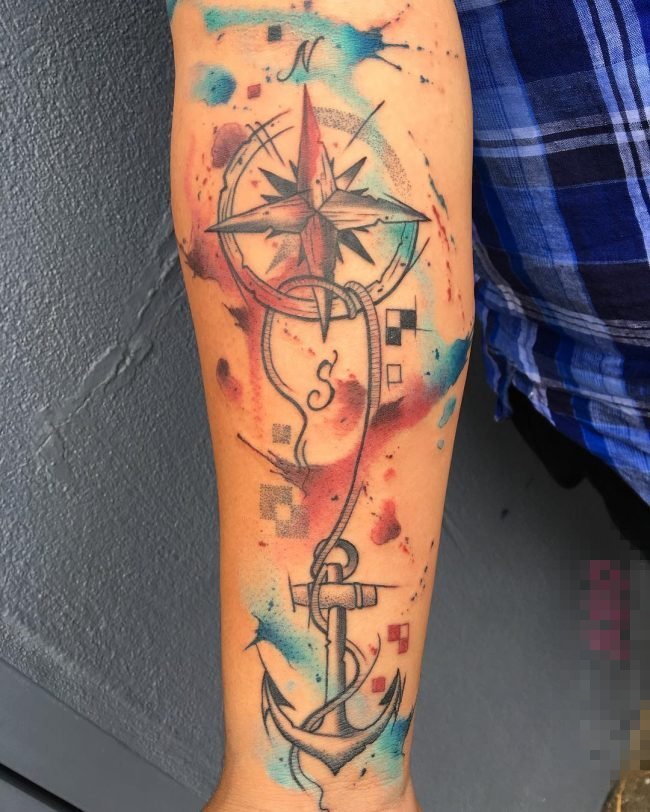 男生手臂上彩绘泼墨指南针和船锚纹身图片
