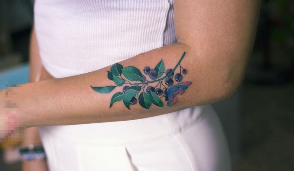 女生手臂上彩绘清新植物与蝴蝶纹身图片