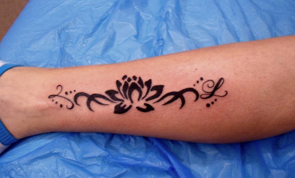 女生小腿上黑色抽象线条唯美植物莲花纹身图片