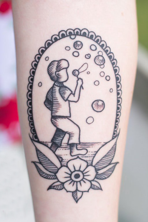 女生小腿上黑色点刺几何线条花朵和卡通人物纹身图片