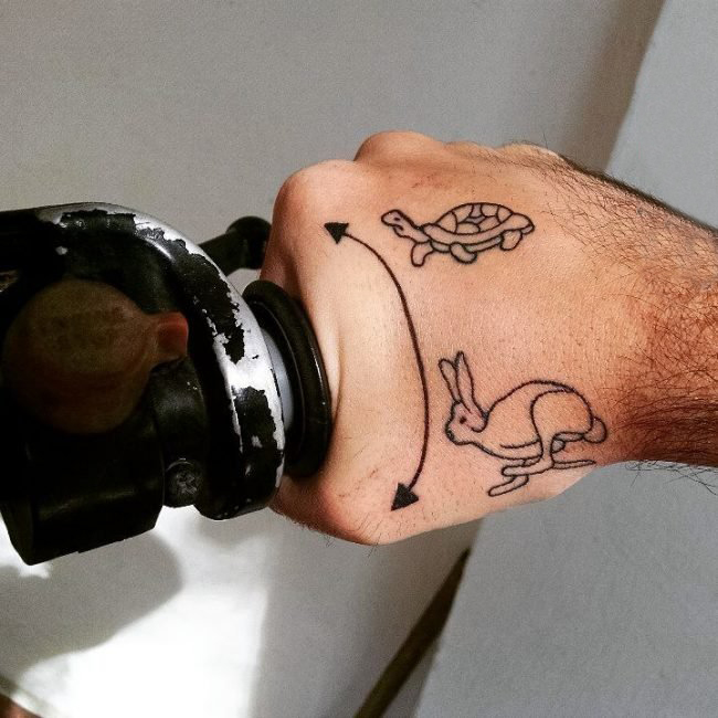 男生手背上黑色简单线条小动物乌龟和兔子纹身图片