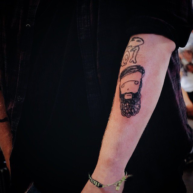 男生手臂上黑色简单抽象线条卡通人物纹身图片