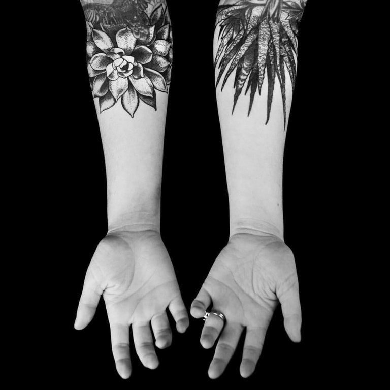 女生手臂上黑色点刺简单线条植物叶子和花朵纹身图片