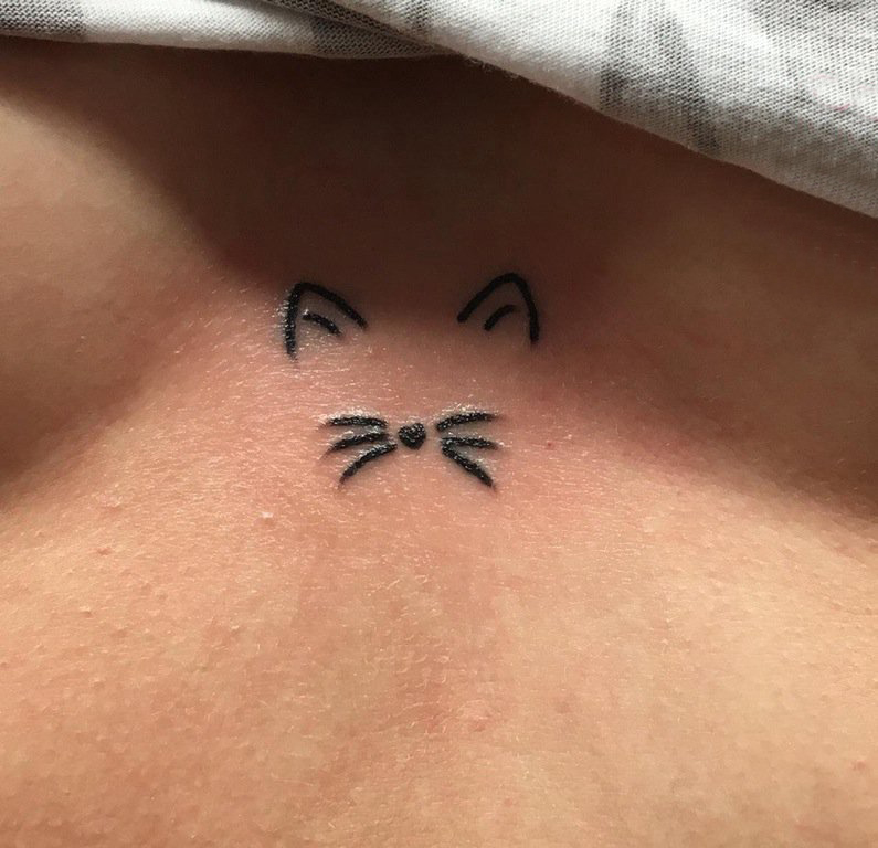 女生胸口上黑色线条创意精致猫咪纹身图片