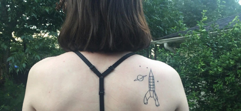 女生后肩上黑色几何简单线条星球和火箭纹身图片