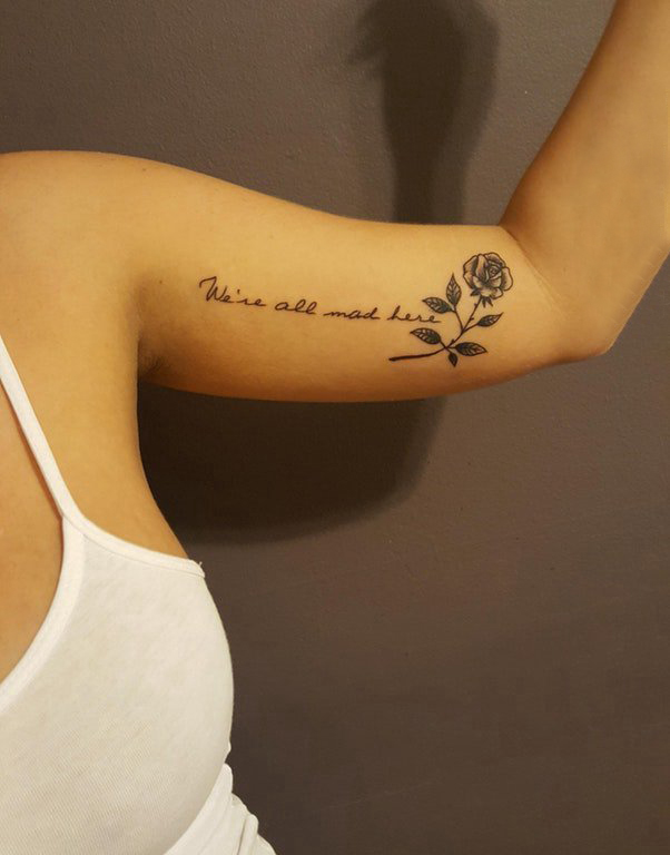 女生手臂上黑色点刺简单线条花体英文和花朵纹身图片