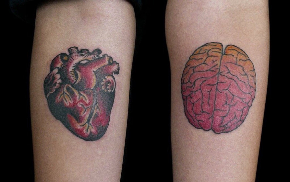 男生手臂上彩绘渐变抽象线条心脏和大脑纹身图片
