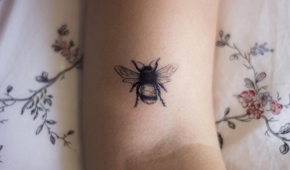 女生手臂上黑色点刺技巧简单线条小动物蜜蜂纹身图片